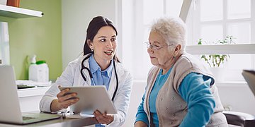 Eine Hausärztin berät eine ältere Patientin im Gespräch.