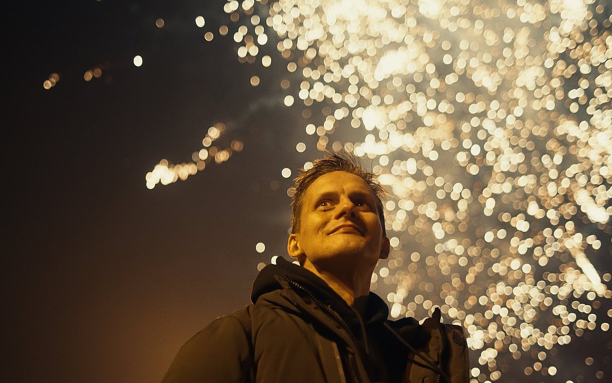 Symbolbild Selbsthilfe: Junger Mann vor einem Feuerwerk