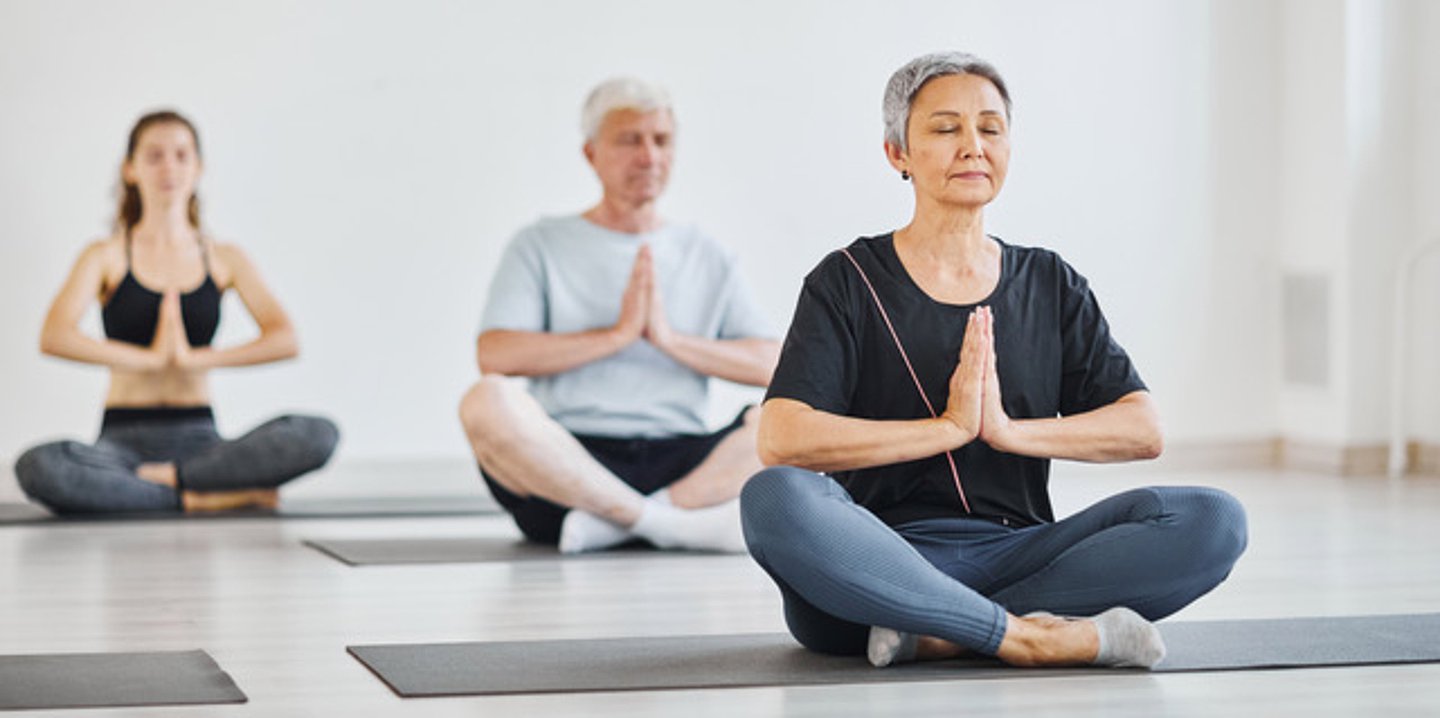 Das Foto zeigt Männer und Frauen beim Yoga.