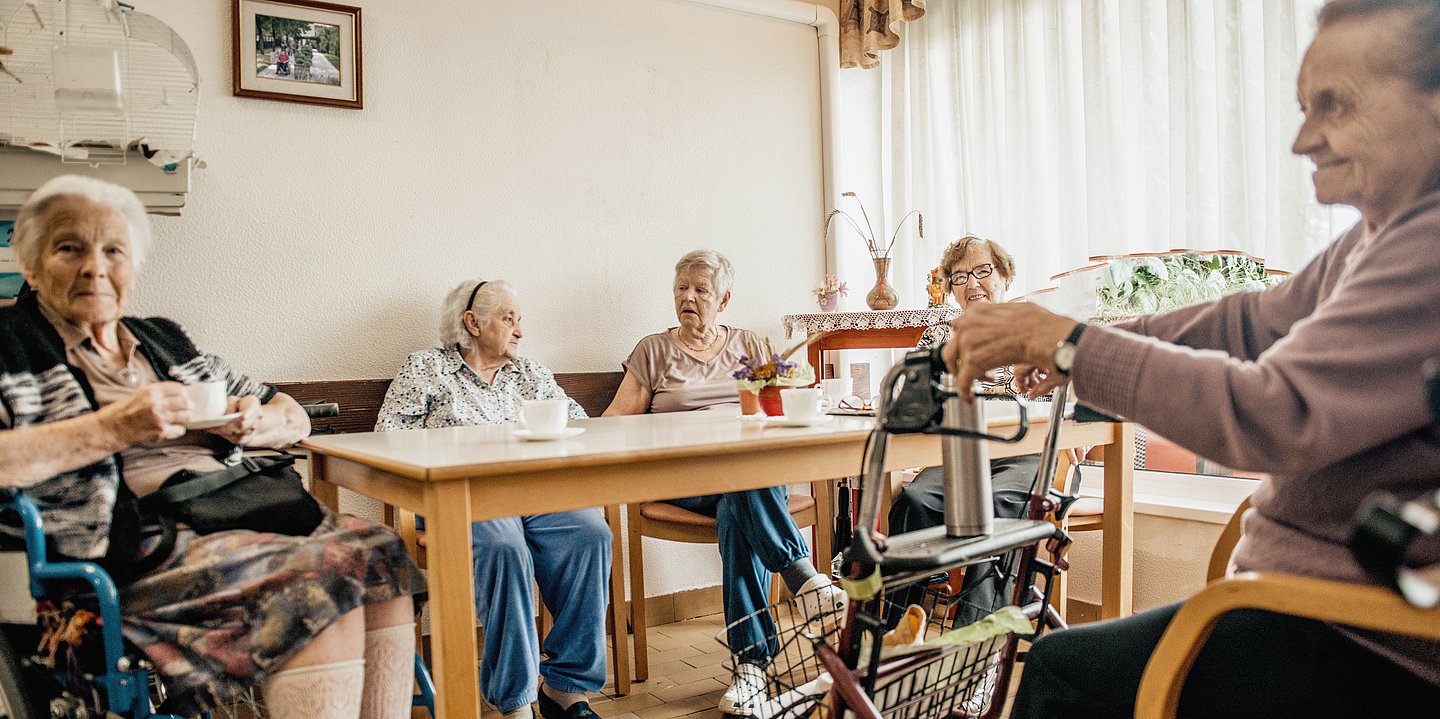 Bewohnenden im Pflegeheim sitzen an einem Tisch