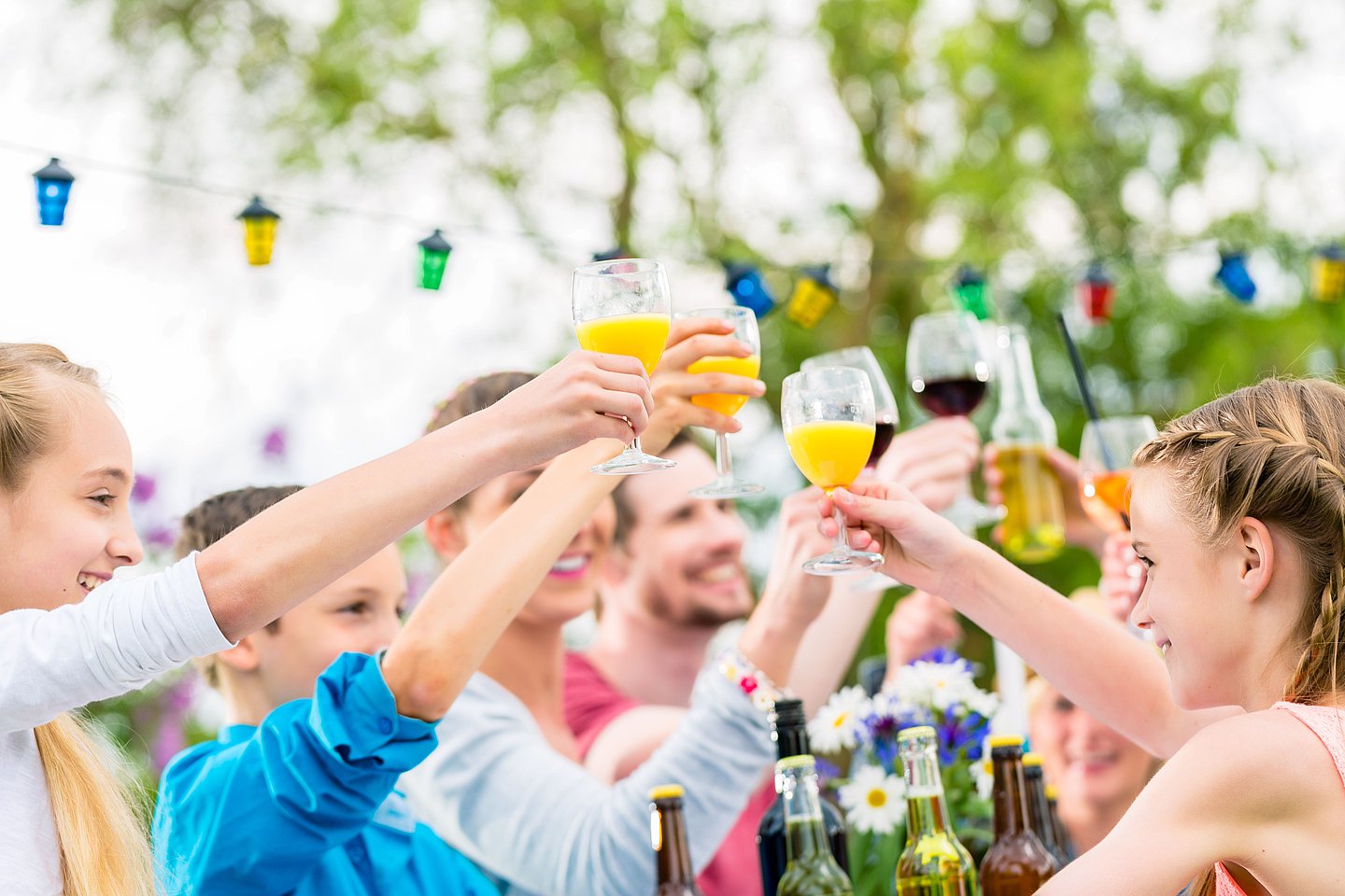 Fröhliche Menschen erheben ihre Gläser bei einem Nachbarschaftsfest