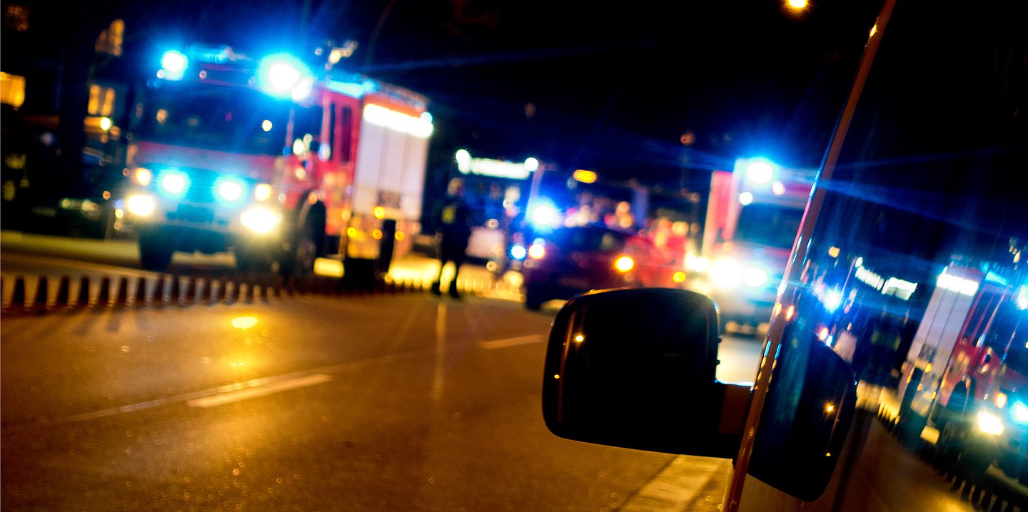 Foto: Auf einer Straße stehen mehrere Rettungswagen mit Blaulicht.