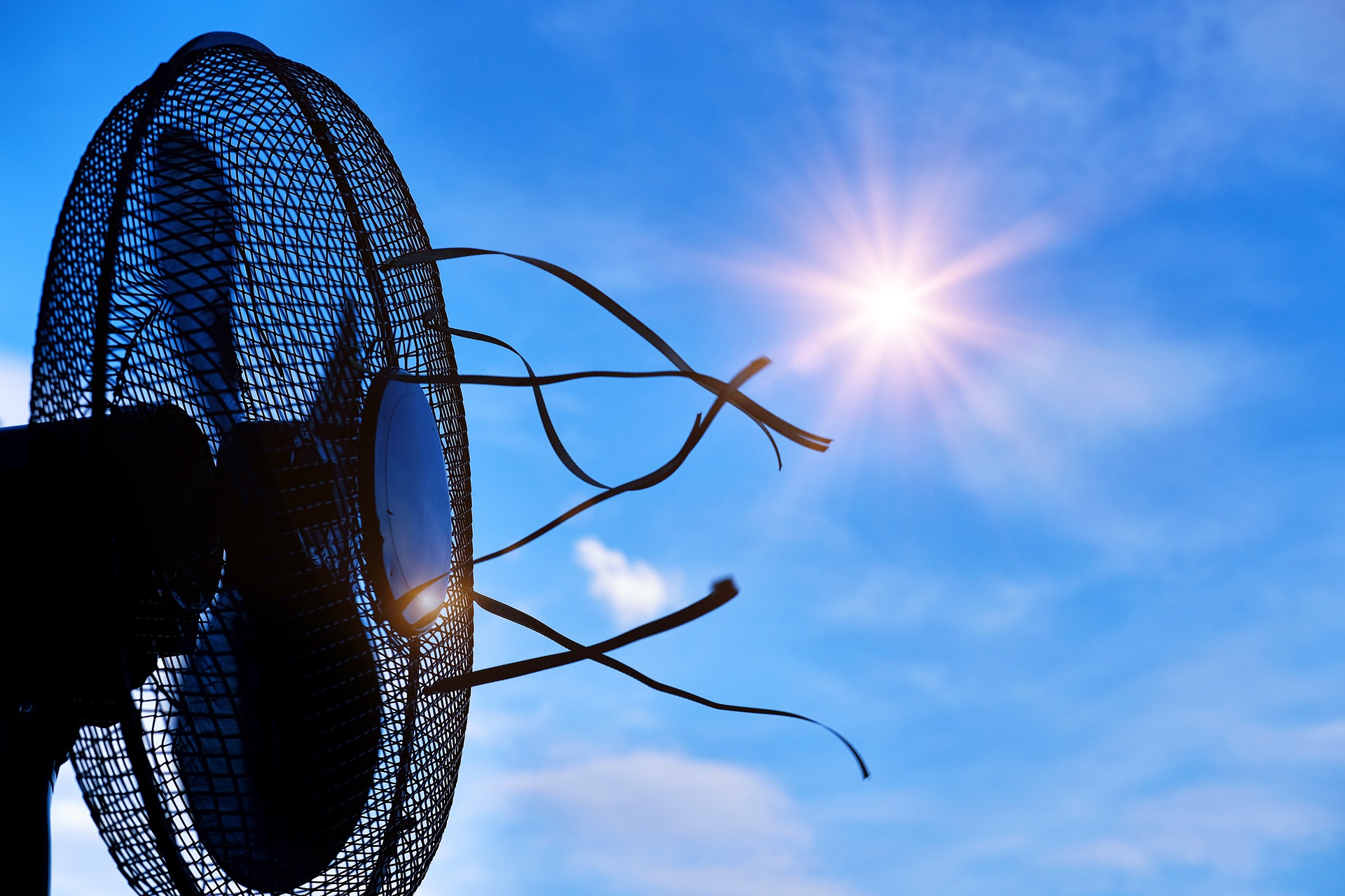 Symbolbild Hitze: Ventilator vor der Sonne am blauen Himmel