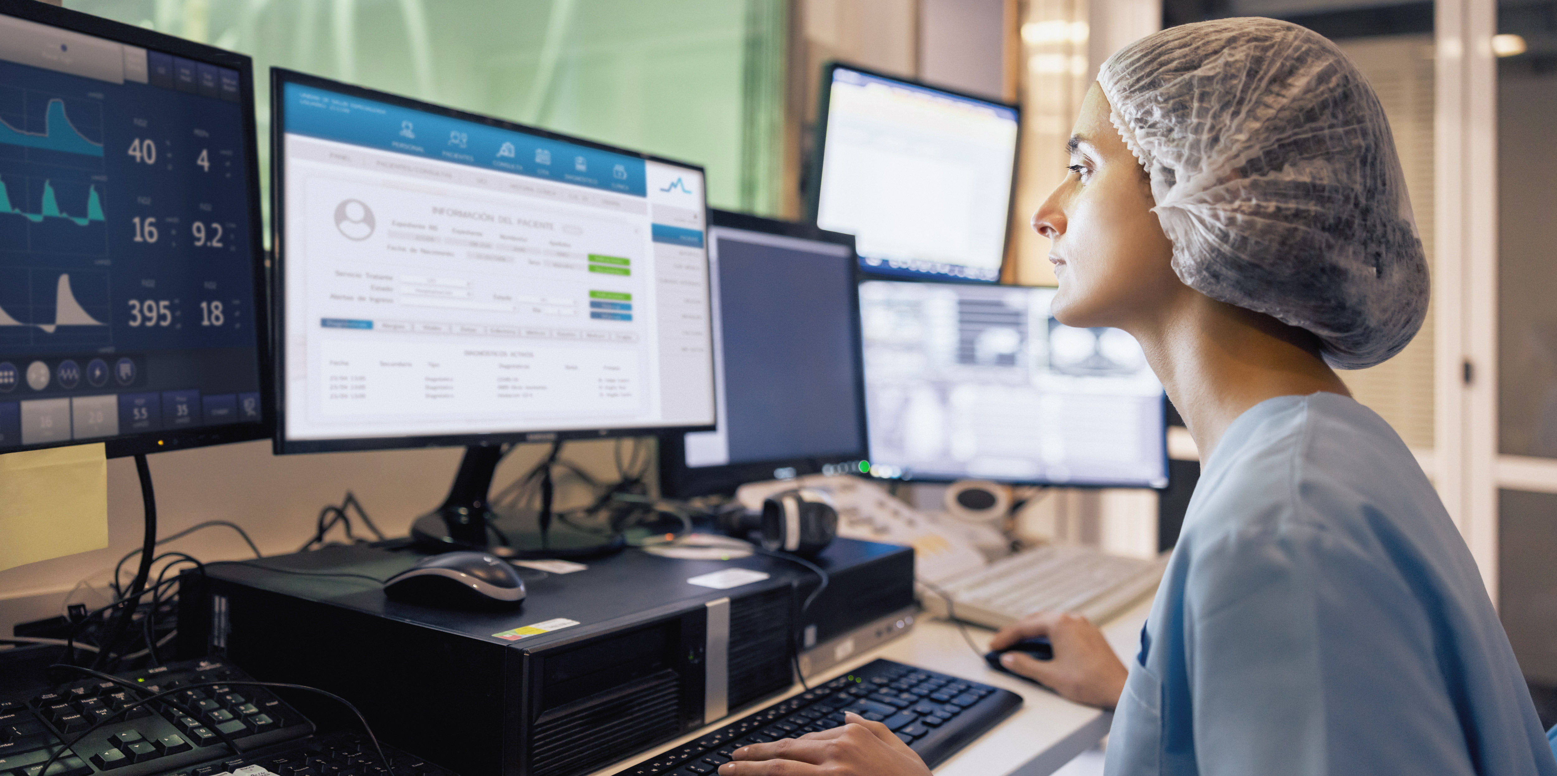 Foto: Eine Pflegekraft schaut auf mehrere Monitore mit verschiedenen Daten.