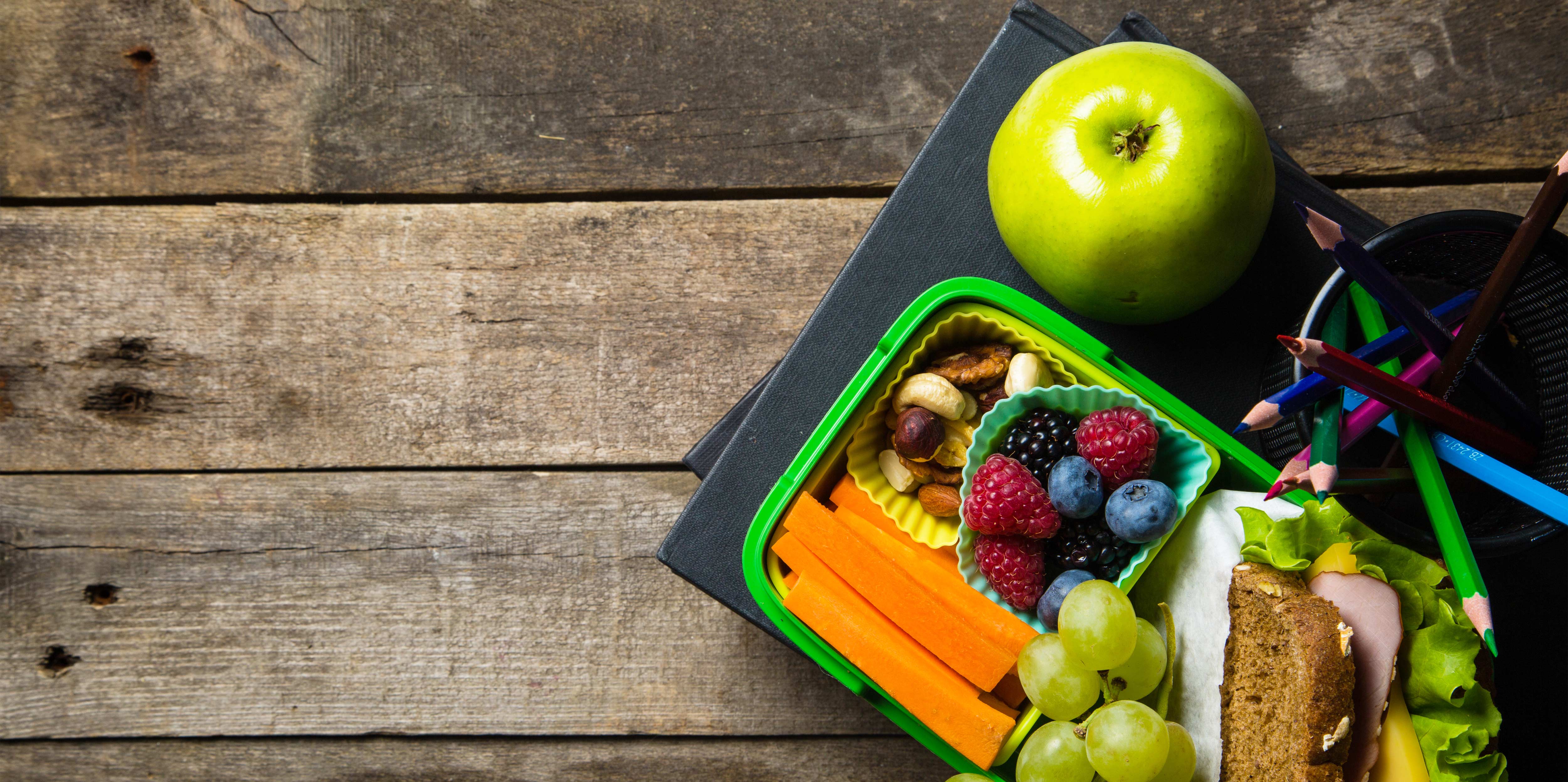 Pusenbox gefüllt mit Obst, Gemüse und Vornkornbrot