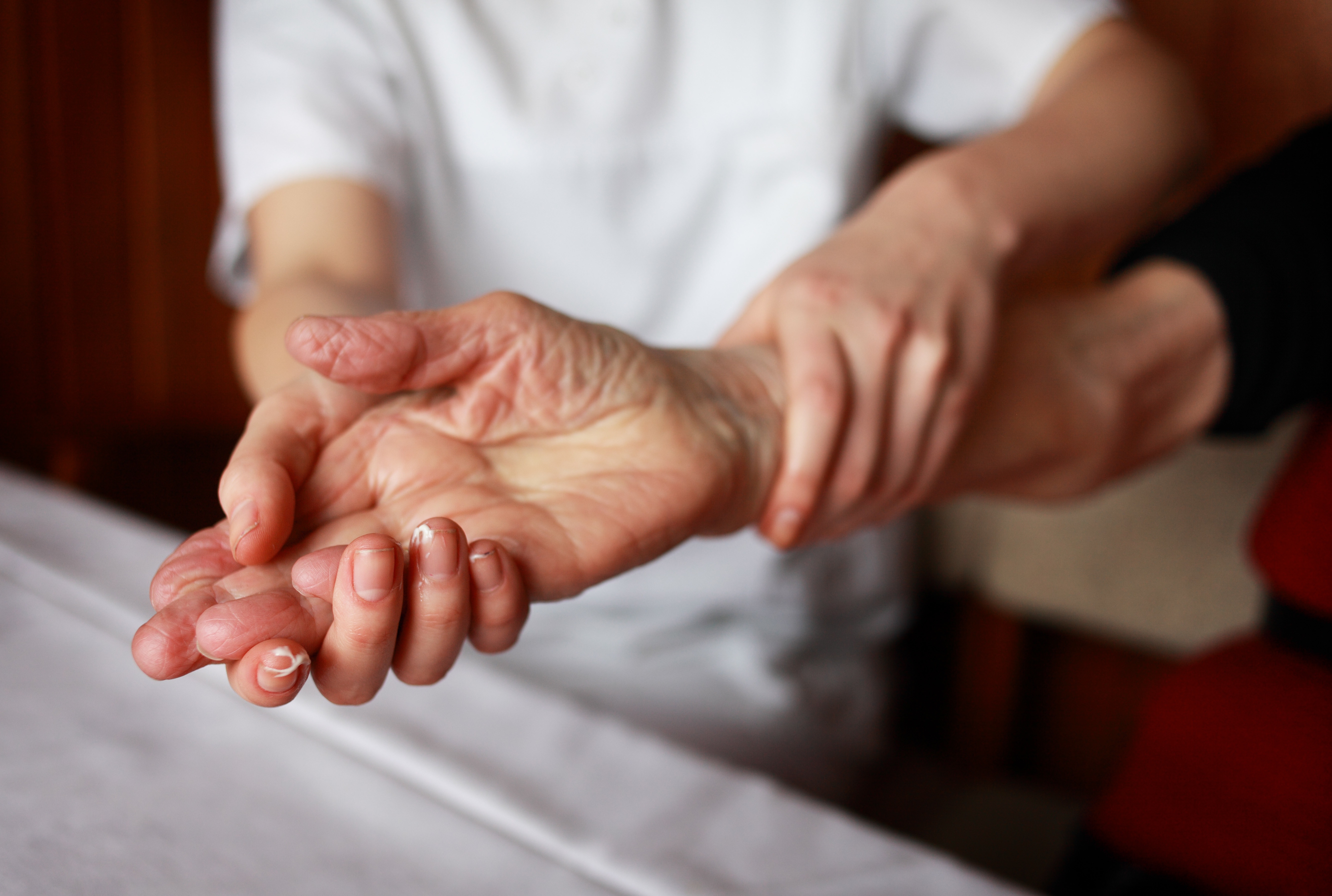 Eine Pflegekraft hält die Hand einer älteren Dame.